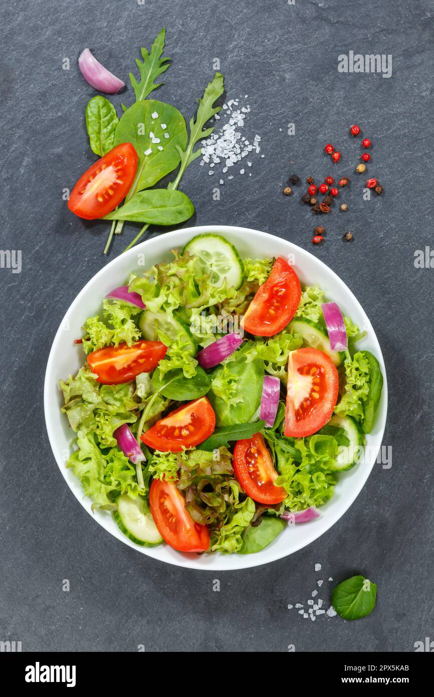 Gemischter Salat mit frischen Tomaten gesundes Essen Essen von oben Porträt Format auf einem Schiefer Stockfoto