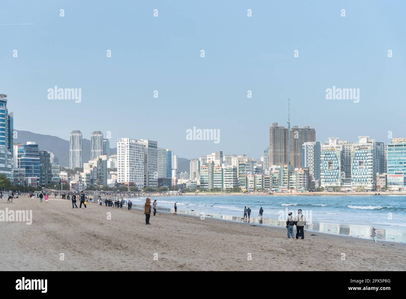Touristenspaziergänge am Strand Busan Gwangalli mit Wolkenkratzern im Hintergrund Stockfoto
