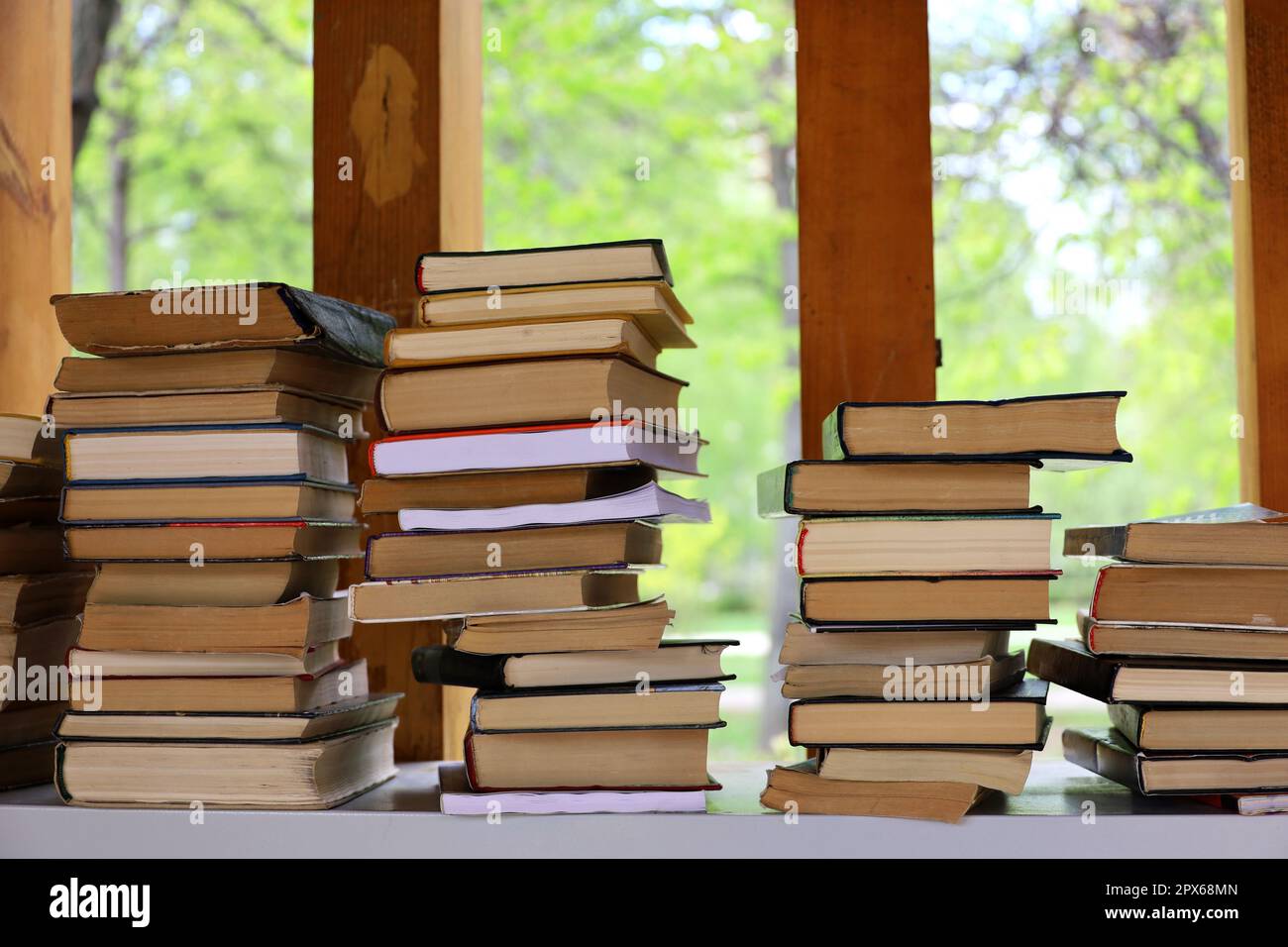 Bücherstapel in einem Park zum Überqueren von Büchern. Hintergrund für Literatur, Buchhandlung, Bibliothek Stockfoto