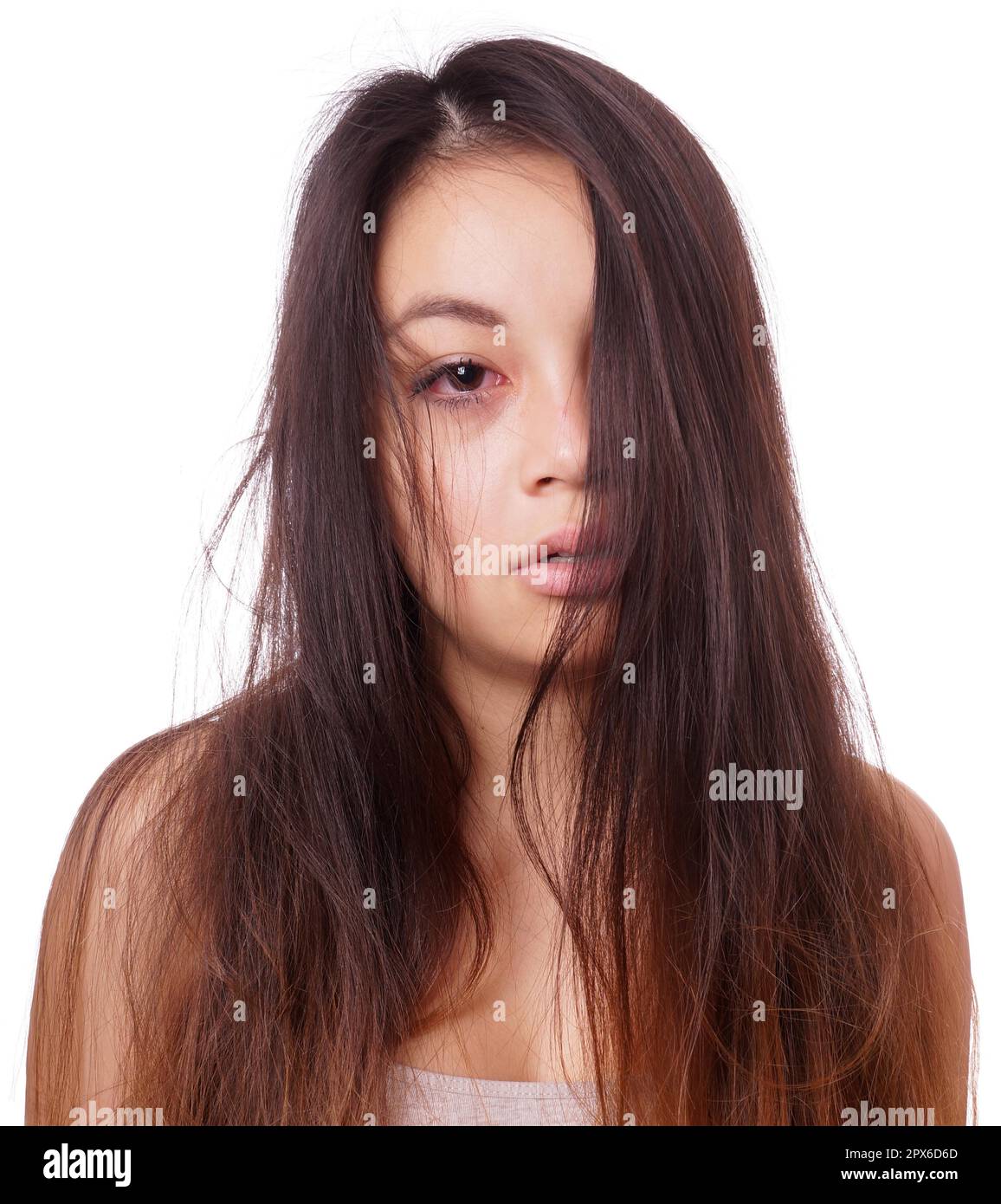 Traurige junge asiatische Frau mit zerzausten Haaren und roten Augen, die weinen Stockfoto