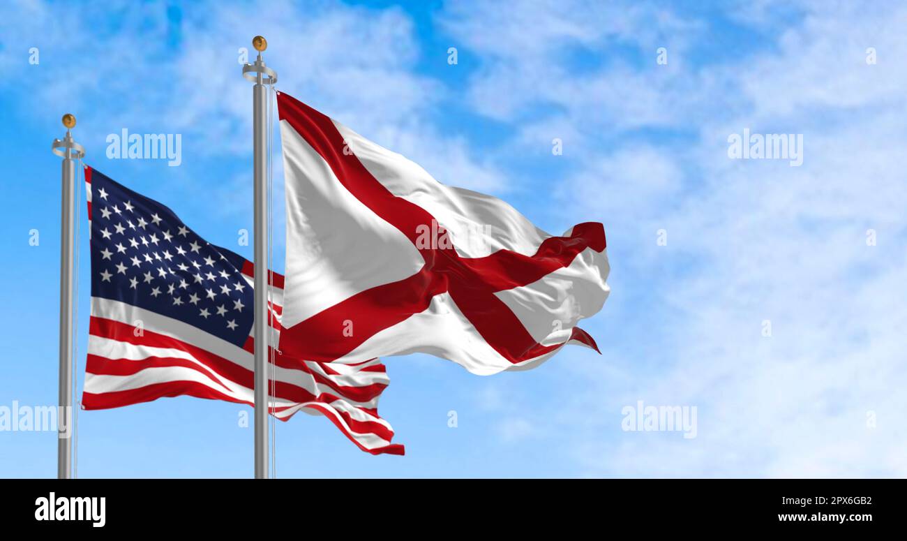 Die Flagge des Bundesstaates Alabama, die an einem sonnigen Tag neben der Nationalflagge der Vereinigten Staaten wackelt. Die Flagge von Alabama ist mit einem roten Kreuz auf einem gekennzeichnet Stockfoto