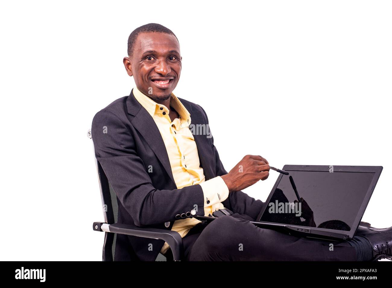 Seriöser Geschäftsmann, der auf einem Stuhl sitzt und seinen Stift lächelnd auf den Laptop-Bildschirm richtet. Stockfoto