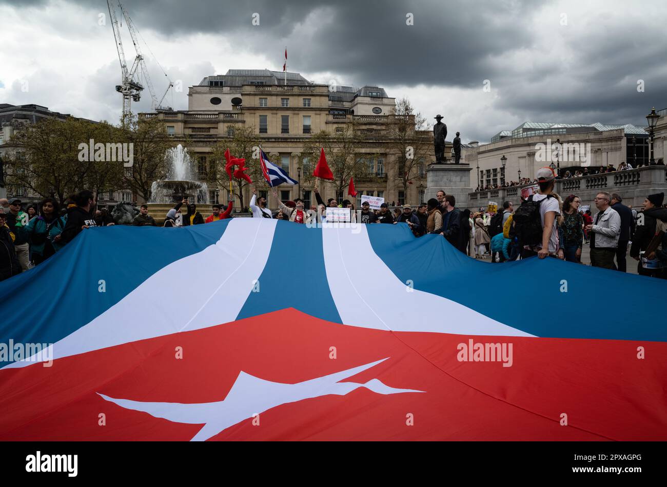 Am 1 2023. Mai entfalten Demonstranten am Trafalgar Square in London eine riesige kubanische Flagge. Stockfoto