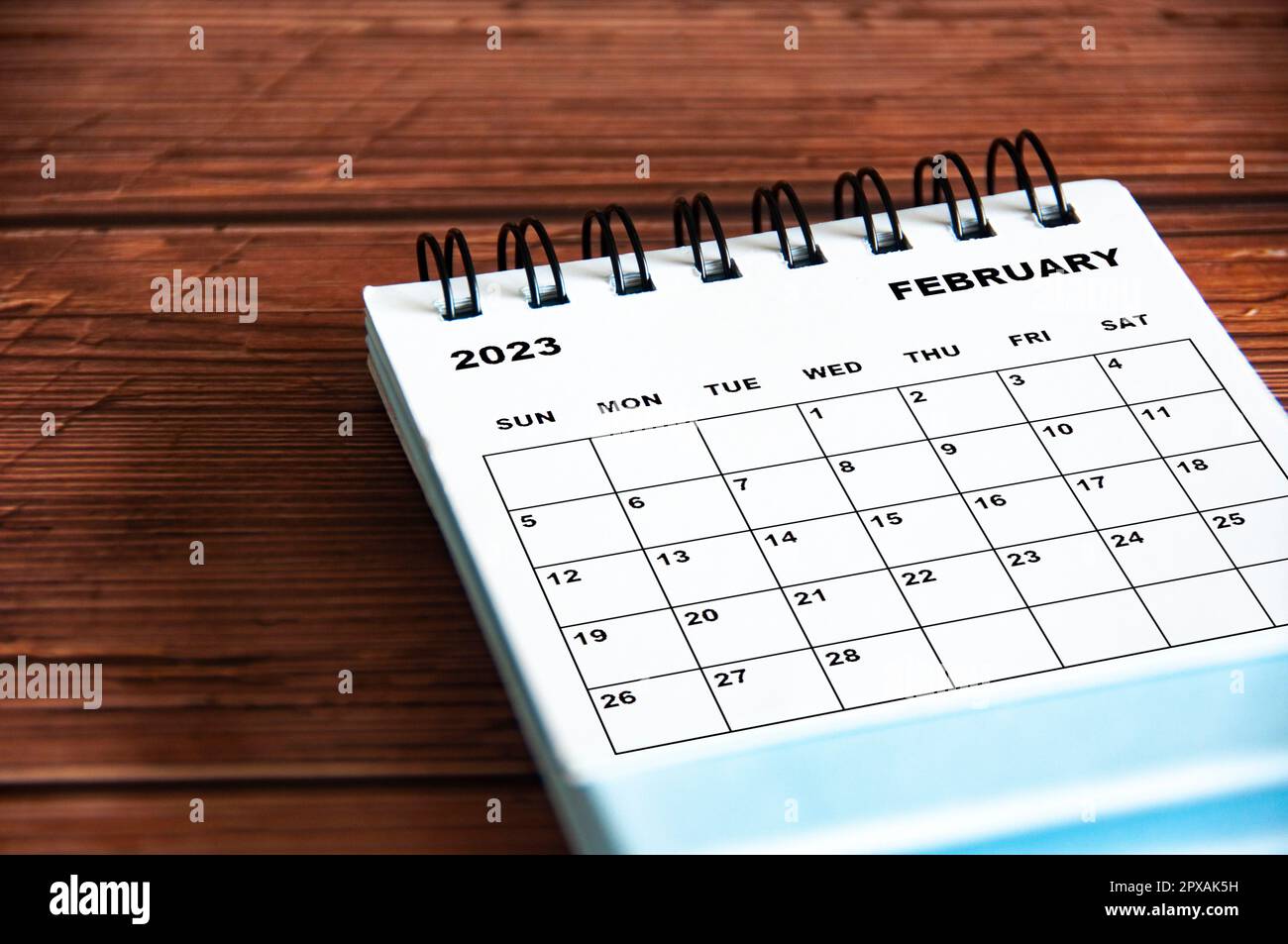 Februar 2023 weißer Tischkalender auf Holzhintergrund. Stockfoto