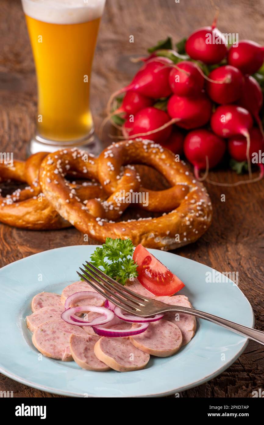 bayerischer Wurstsalat auf dunklem Holz Stockfoto