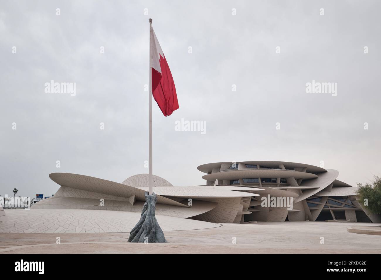 Doha, Katar - 2023. April: Das Nationalmuseum von Katar, entworfen vom Architekten Jean Nouvel, das Museum hat die Form einer Wüstenrose mit der katarischen Flagge Stockfoto