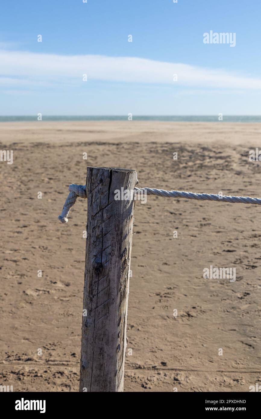 Nahaufnahme eines um die Holzsäule gebundenen Seils. Siehe Hintergrund. Konzept. Stockfoto