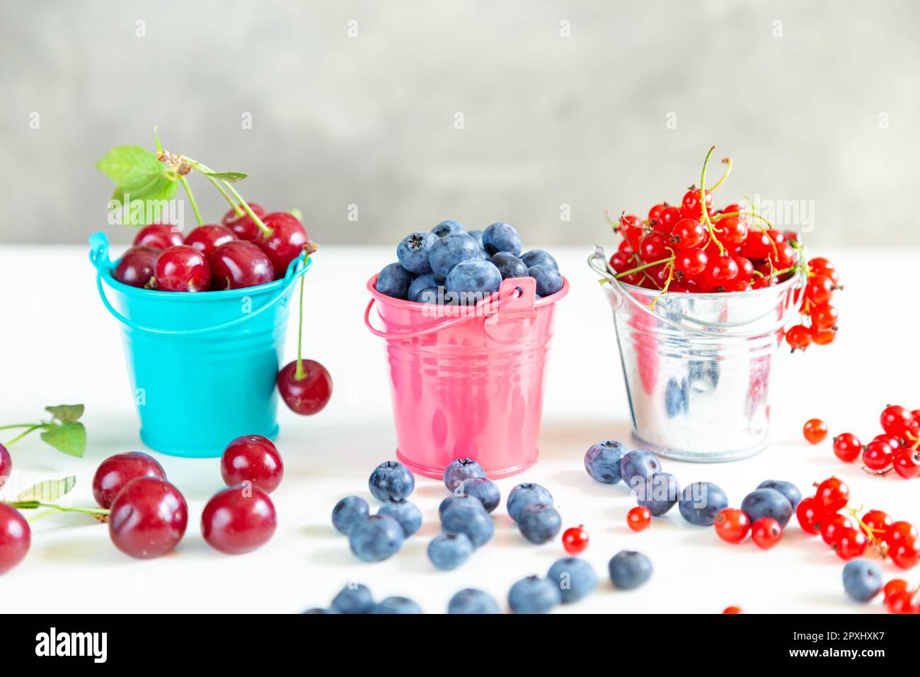 Mischen Sie frische Beeren in kleinen Eimern. Saftige Sommertapete. Stockfoto