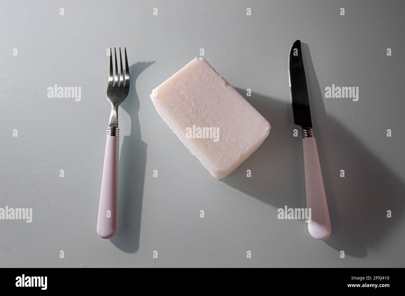 Eine Nahaufnahme eines Schmalzblocks mit Messer und Gabel auf dem Tisch Stockfoto