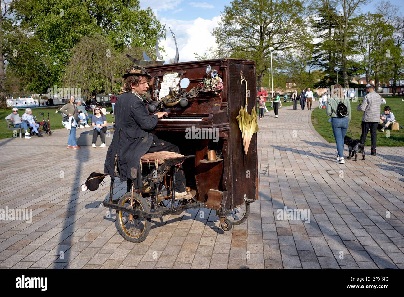 Straßenmusiker, der ein mobiles Klavier spielt, das er mit Fußtritten navigiert. Stratford upon Avon England Großbritannien. Straßenunterhalter Stockfoto