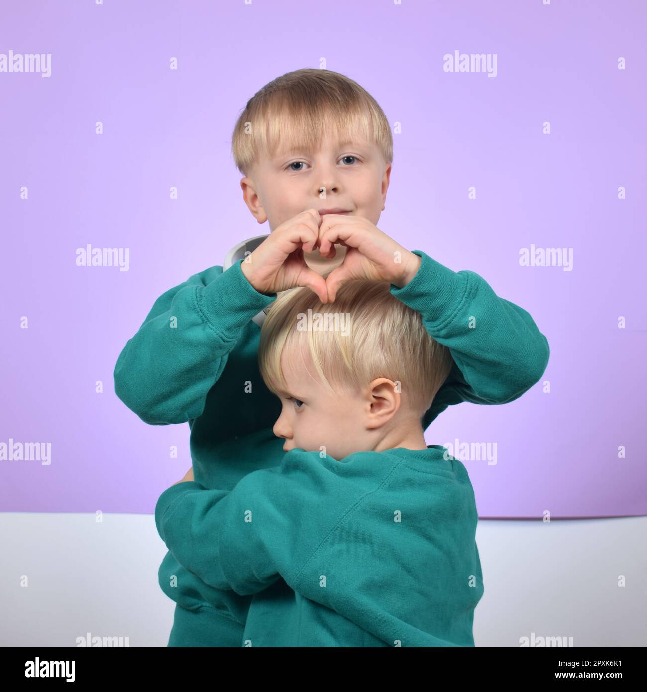 Der ältere Bruder umarmt den jüngeren Stockfoto