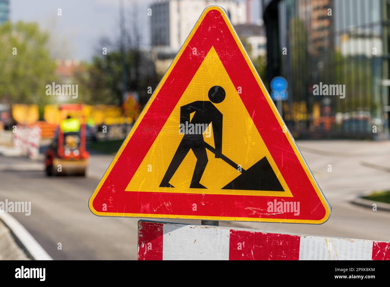 Männer am Arbeitsplatz Verkehrsschild an Baustelle für Straßeninstandhaltungsprojekte, selektiver Fokus Stockfoto