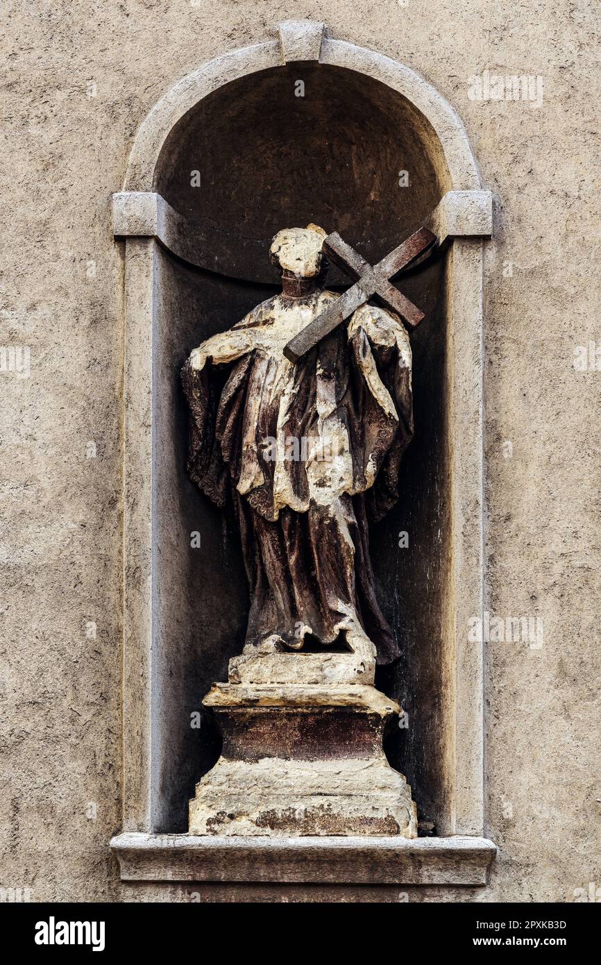 Abgenutzte und beschädigte Statue an der katholischen Kirchenfassade, Details der christlichen Architektur Stockfoto