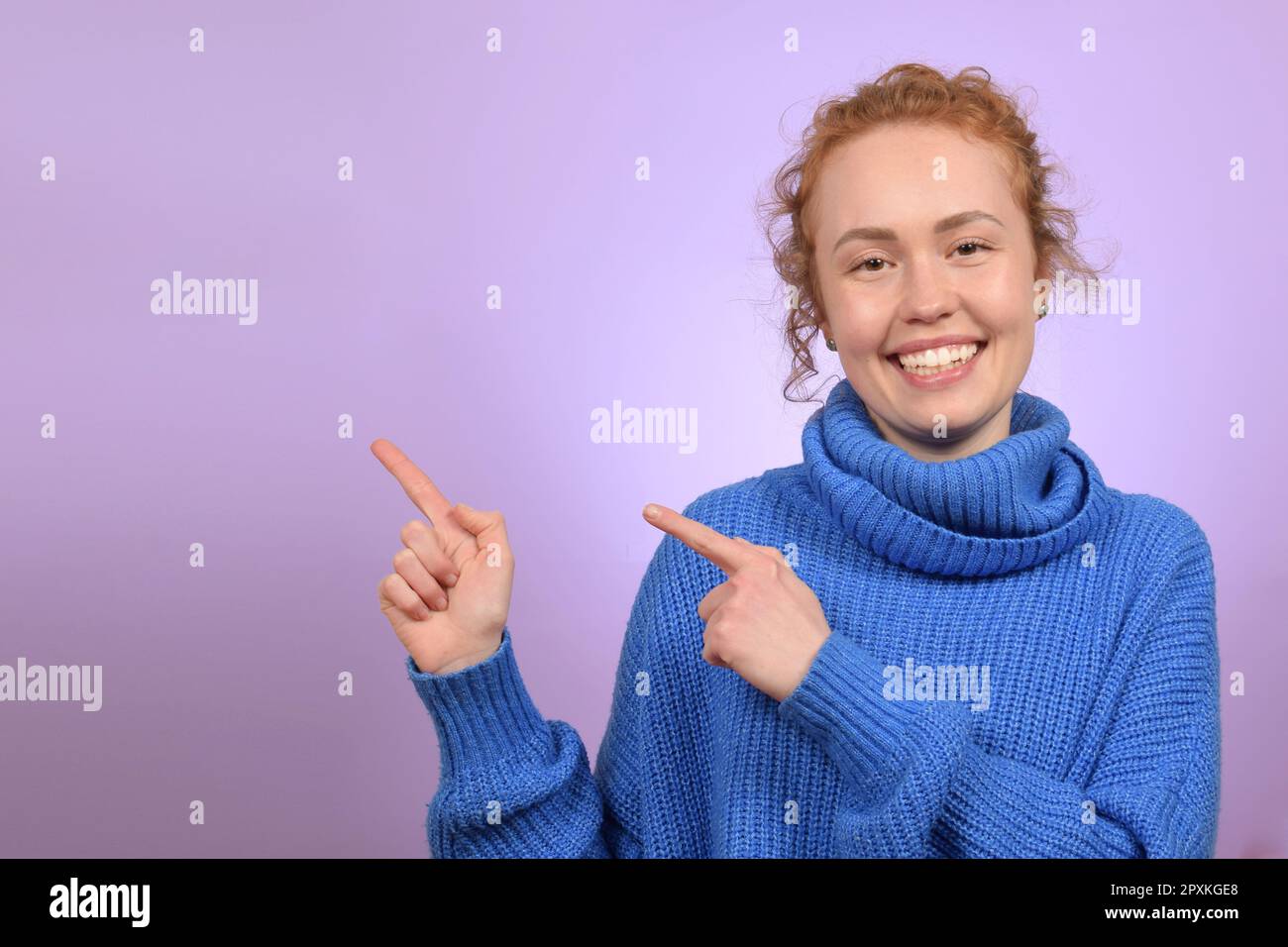 Junge, hübsche Frau, die mit dem Finger in die Richtung zeigt Stockfoto