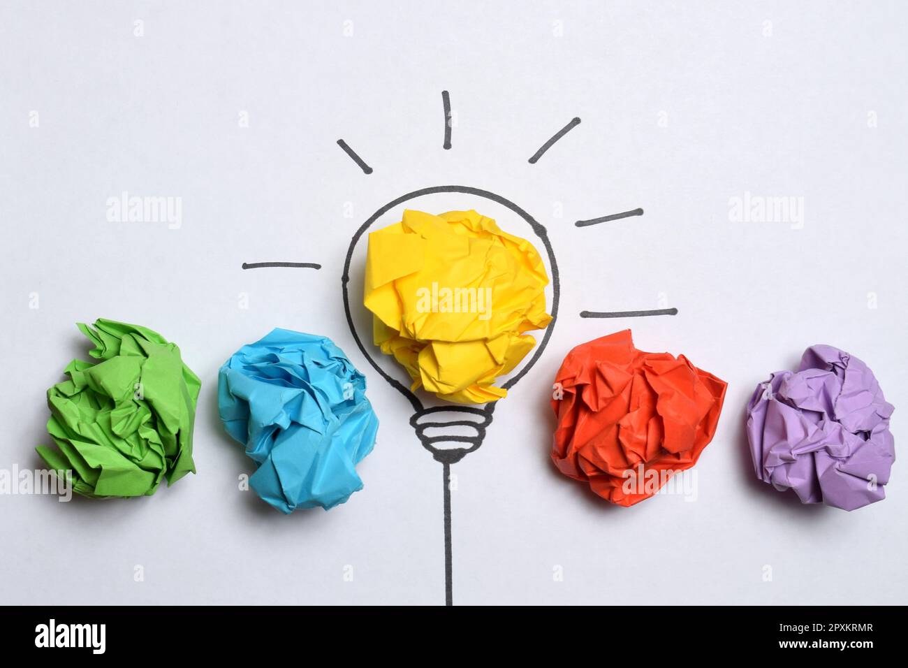 Kreatives Denken und Innovationskonzept. Gelbe Farbe der Papierschrottkugel mit Glühlampensymbol Stockfoto