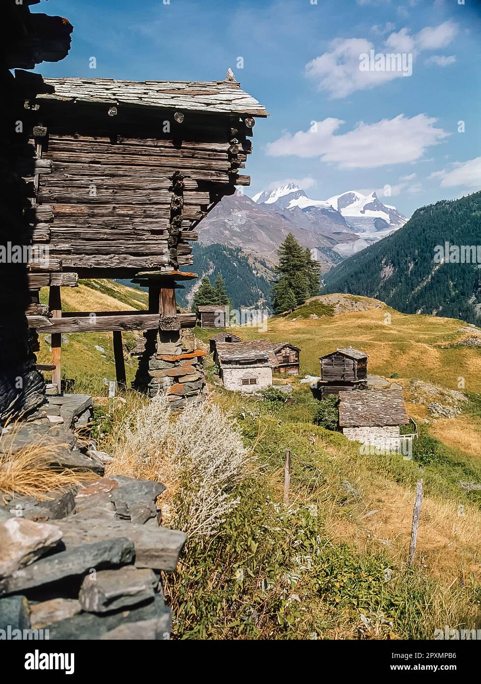 Diese Bilderserie zeigt die Berge in der Nähe des Schweizer Kurorts Zermatt, die hier mit den malerischen Heuscheunen im Dorf Zmutt zu sehen sind, mit Blick über das Tal auf die Gipfel des Rimpfischhorns und Strahlhorns. Stockfoto