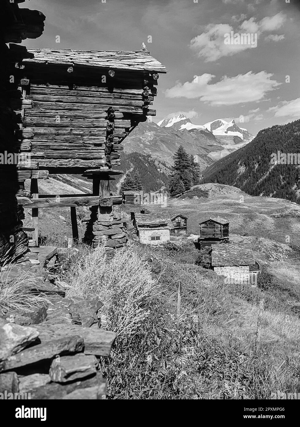 Diese Bilderserie zeigt die Berge in der Nähe des Schweizer Kurorts Zermatt, die hier mit den malerischen Heuscheunen im Dorf Zmutt zu sehen sind, mit Blick über das Tal auf die Gipfel des Rimpfischhorns und Strahlhorns. Stockfoto