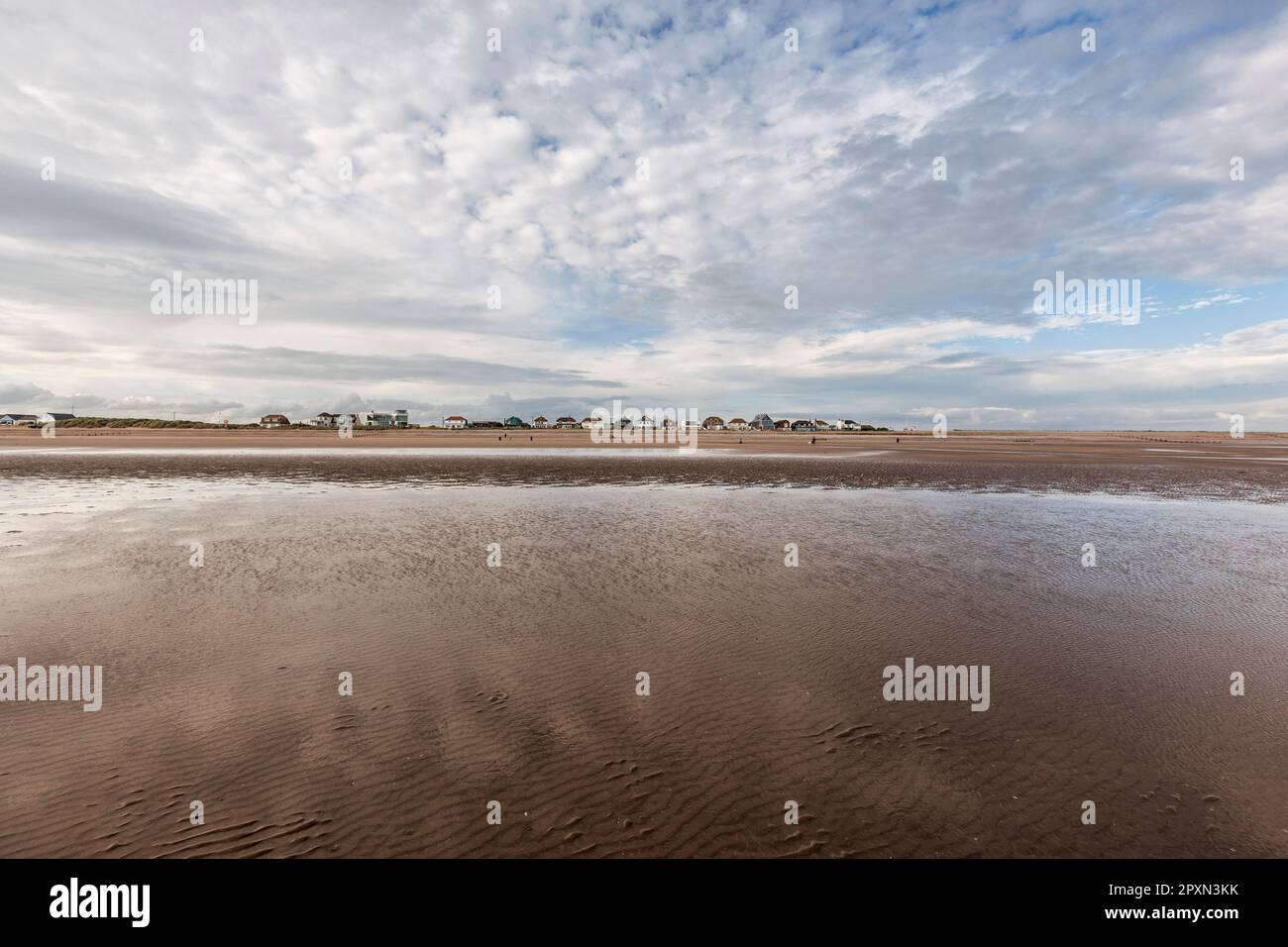 Große Himmelshäuser auf Dünen am sonnigen, windigen Camber Sands in Rye Bay am English Channel an der Grenze zu Sussex Kent und Wolkenformationen. Beliebt für Wassersportarten Stockfoto