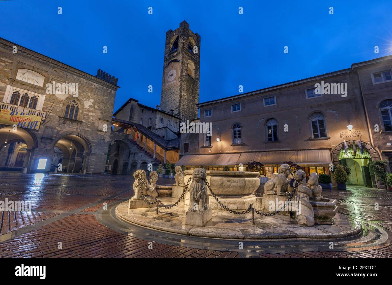 Der Civic Tower heißt Campanone in der Altstadt. Palazzo della Ragione (links) und Palazzo del Podesta (rechts) mit Brunnen auf der Piazza Vecchia in der Abenddämmerung Stockfoto