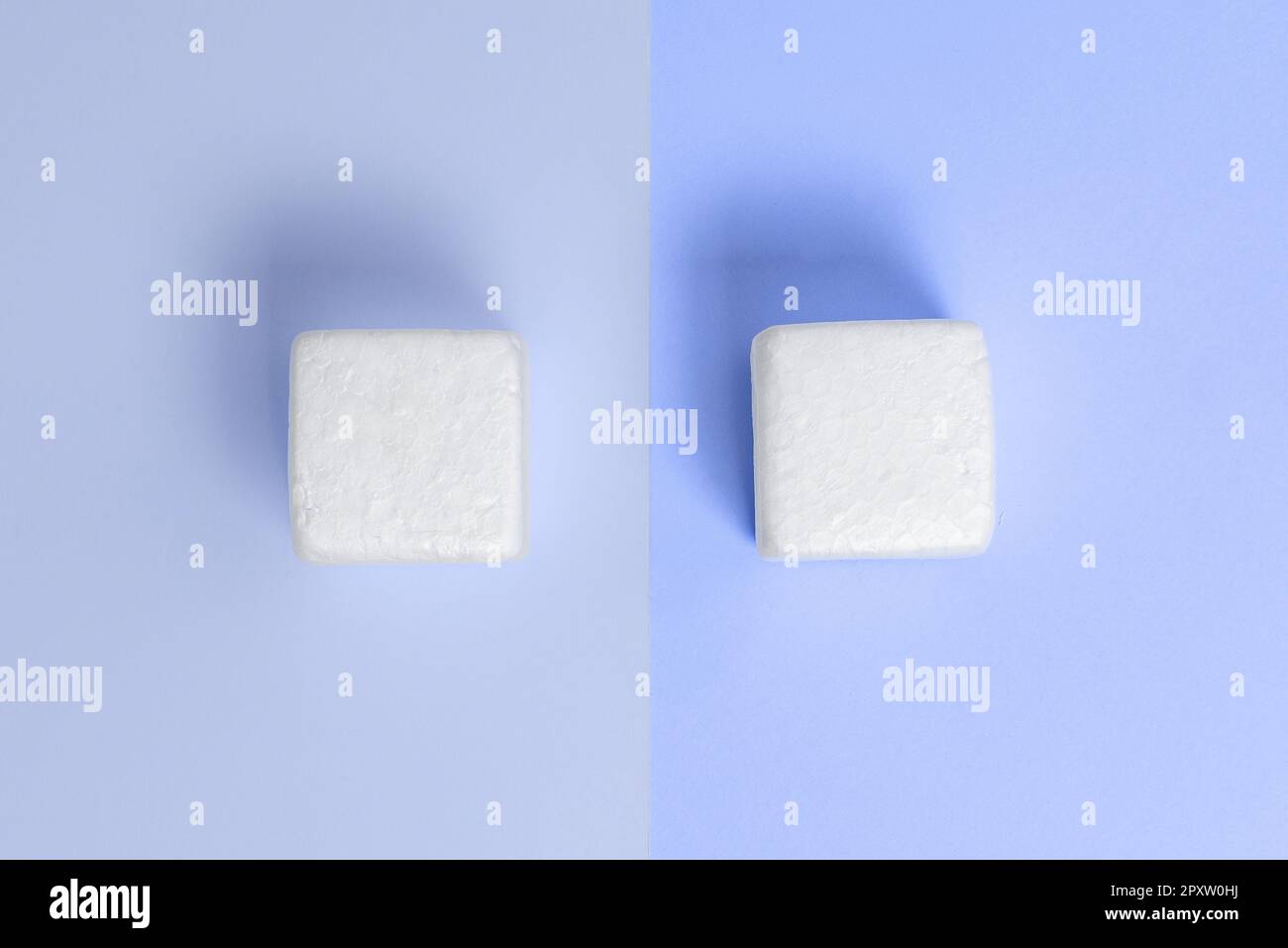 Weiße Styroporwürfel auf dem farbigen Schreibtisch. Brandneue Informationen. Stockfoto