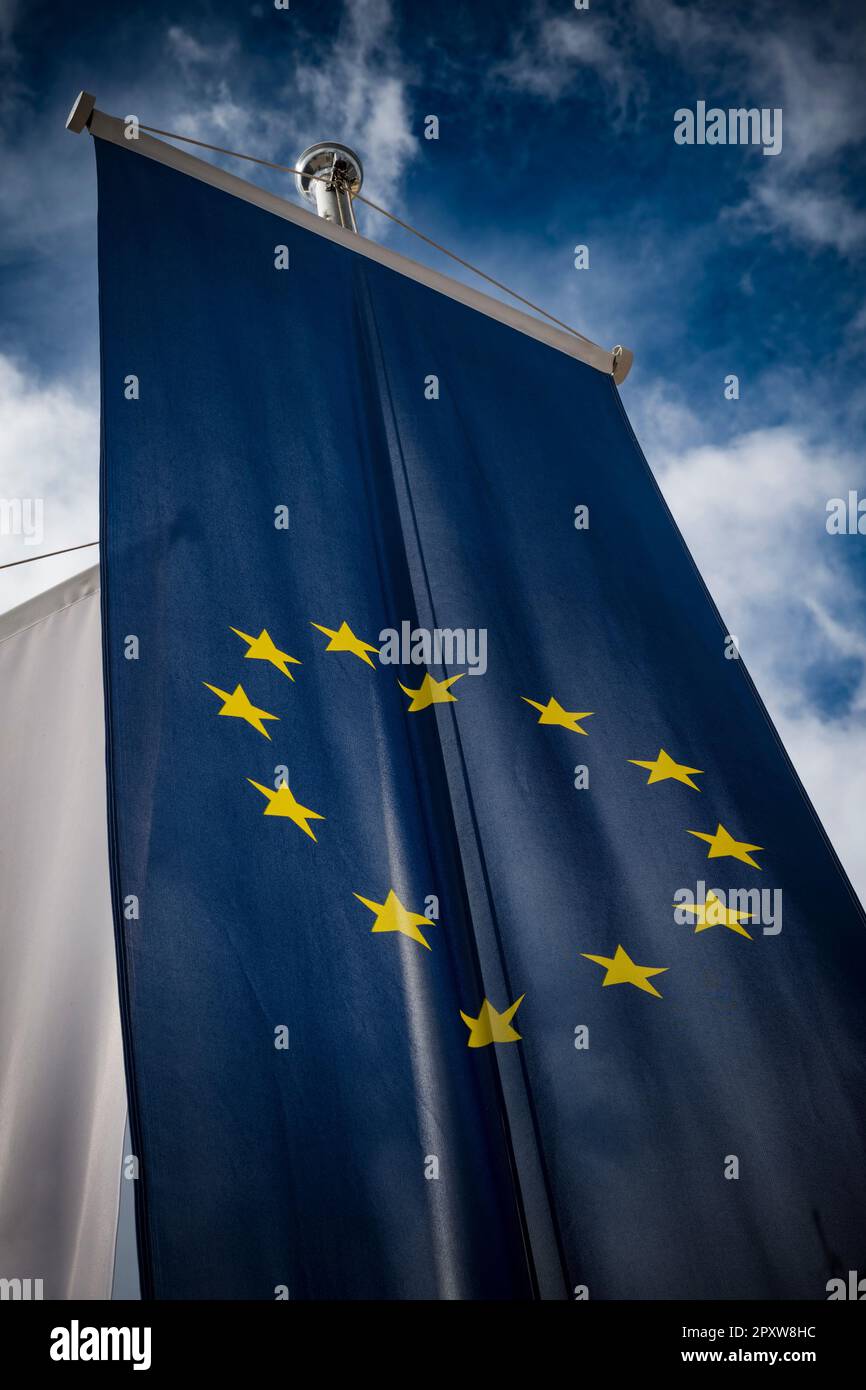Ein Banner der Europäischen Union, das über dem wolkigen Himmel aufragt Stockfoto