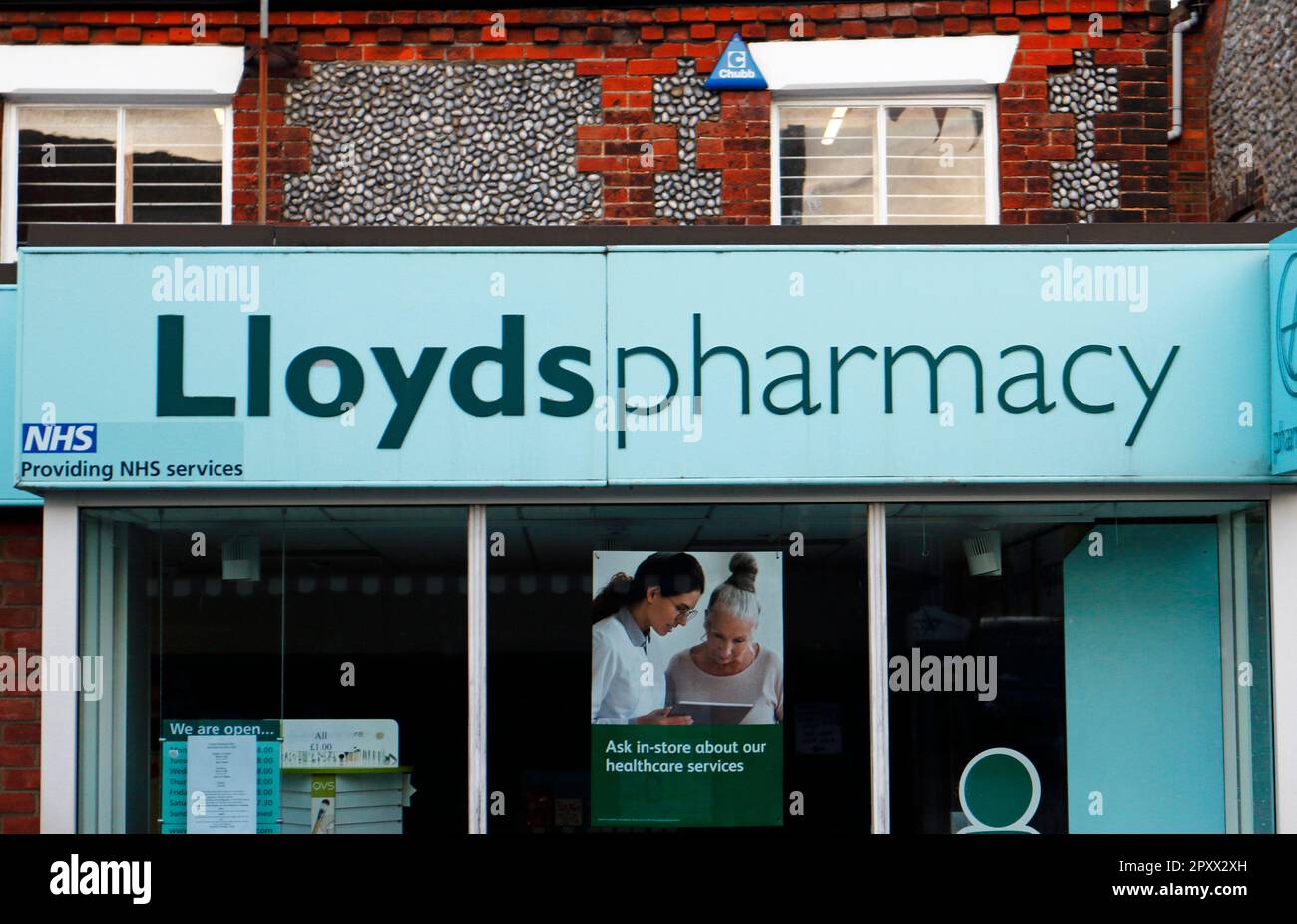 Ein Blick auf die Fassade über der Ladenfront, die für die Lloyds Pharmacy in der North Norfolk-Stadt Sheringham, Norfolk, England, Großbritannien wirbt. Stockfoto