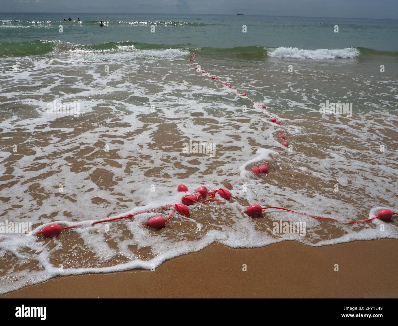 Bojen an einem Seil im Meerwasser. Die Rettungsringe sind rosa gefesselt, um die Leute auf die Wassertiefe aufmerksam zu machen. Rettung des Ertrinkens. Einen Ort abgrenzen Stockfoto