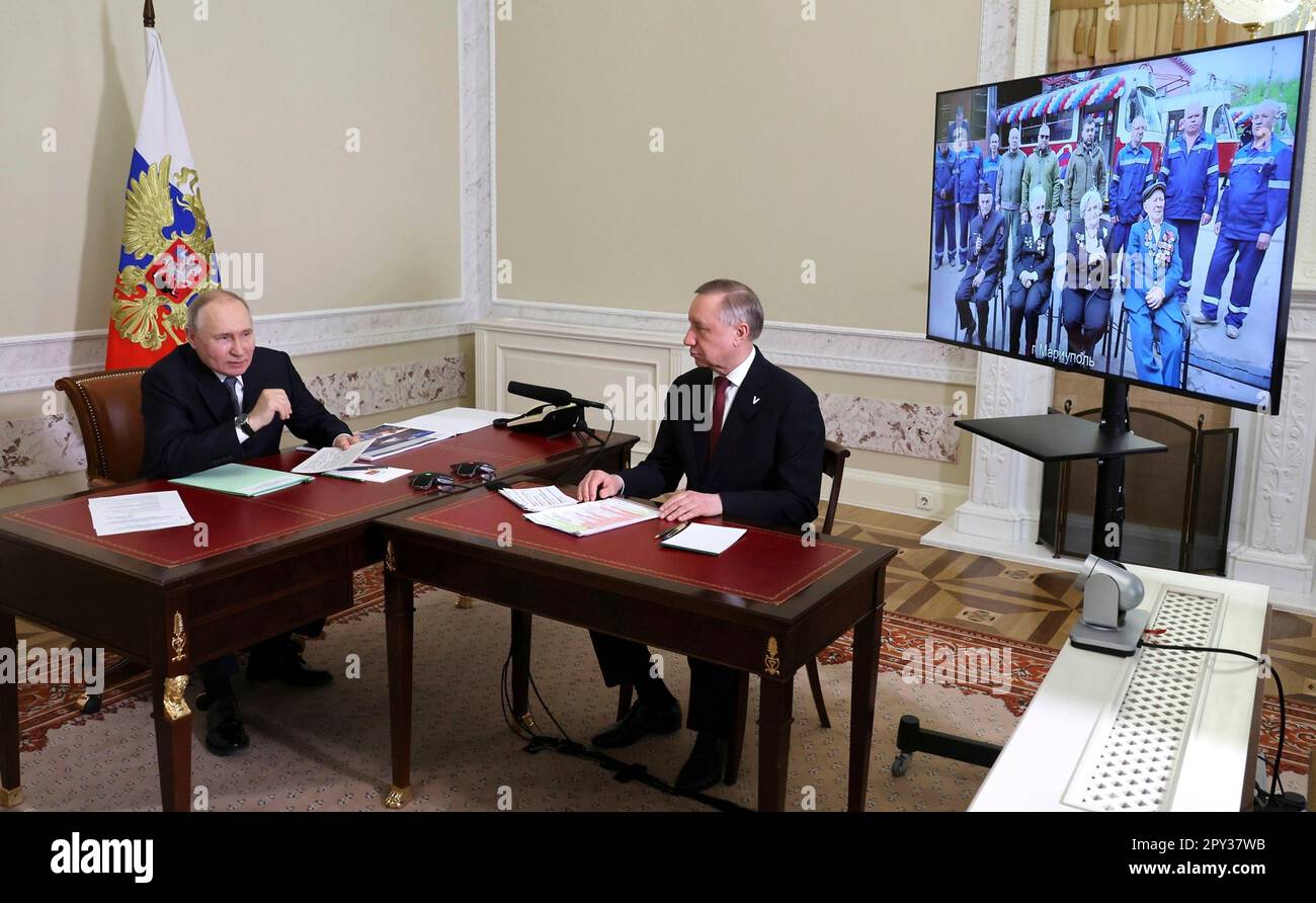 St. Petersburg, Russland. 02. Mai 2023. Der russische Präsident Wladimir Putin und der Gouverneur von Sankt Petersburg Alexander Beglov, rechts, nehmen an einer virtuellen Veranstaltung Teil, bei der das Straßenbahnsystem im besetzten Mariupol am 2. Mai 2023 in St. Petersburg, Russland, gestartet wird. Das öffentliche Verkehrsnetz und der Großteil der Stadt wurden durch die russische Invasion und Besetzung der ukrainischen Stadt Mariupol in der Oblast Donezk zerstört. Kredit: Mikhail Klimentyev/Kremlin Pool/Alamy Live News Stockfoto
