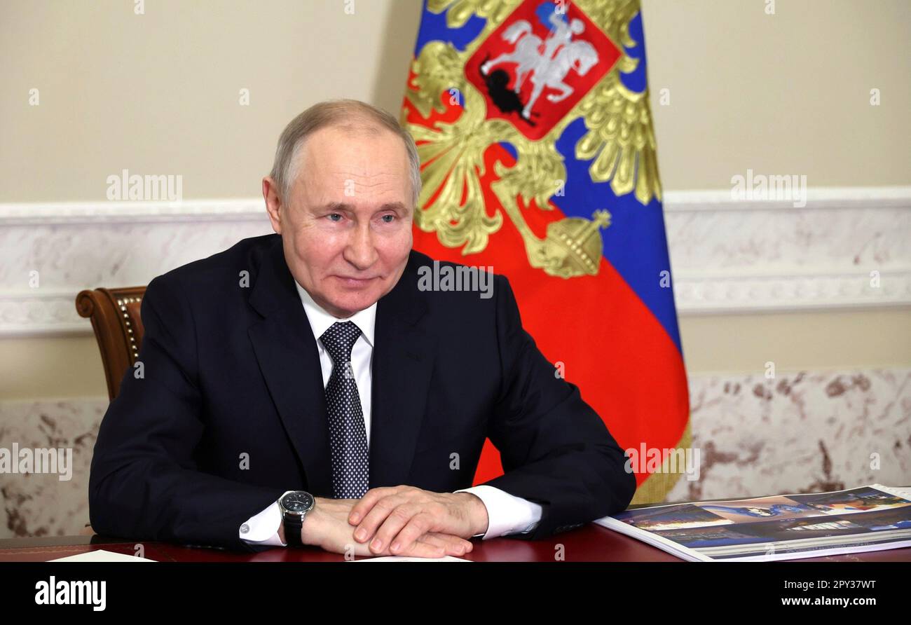 St. Petersburg, Russland. 02. Mai 2023. Der russische Präsident Wladimir Putin lächelt, als er an einer virtuellen Veranstaltung teilnimmt, bei der das Straßenbahnsystem im besetzten Mariupol mit dem Gouverneur von Sankt Petersburg, Alexander Beglov, am 2. Mai 2023 in Sankt Petersburg, Russland, eingeführt wird. Das öffentliche Verkehrsnetz und der Großteil der Stadt wurden durch die russische Invasion und Besetzung der ukrainischen Stadt Mariupol in der Oblast Donezk zerstört. Kredit: Mikhail Klimentyev/Kremlin Pool/Alamy Live News Stockfoto