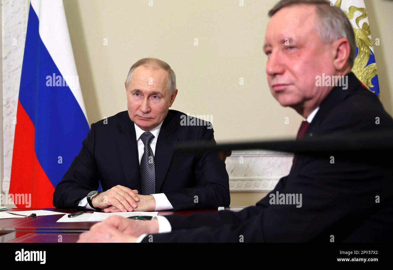 St. Petersburg, Russland. 02. Mai 2023. Der russische Präsident Wladimir Putin und der Gouverneur von Sankt Petersburg Alexander Beglov, rechts, nehmen an einer virtuellen Veranstaltung Teil, bei der das Straßenbahnsystem im besetzten Mariupol am 2. Mai 2023 in St. Petersburg, Russland, gestartet wird. Das öffentliche Verkehrsnetz und der Großteil der Stadt wurden durch die russische Invasion und Besetzung der ukrainischen Stadt Mariupol in der Oblast Donezk zerstört. Kredit: Mikhail Klimentyev/Kremlin Pool/Alamy Live News Stockfoto