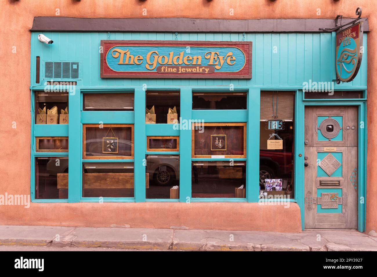 StoreFront for the Golden Eye, ein edler Juwelierladen im Zentrum von Santa Fe, New Mexico, mit türkisfarbenem Holz und rosafarbenem adobe, USA. Stockfoto