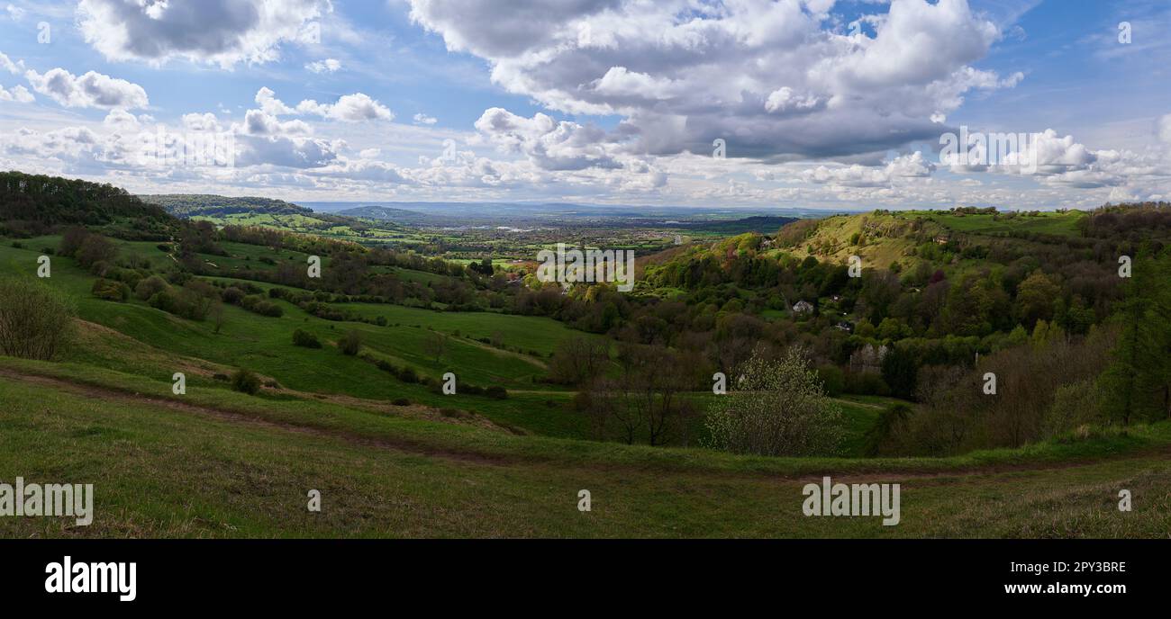 Sanfte Hügel über englischer Landschaft mit blauem Himmel und weißen Wolken im Panorama Stockfoto