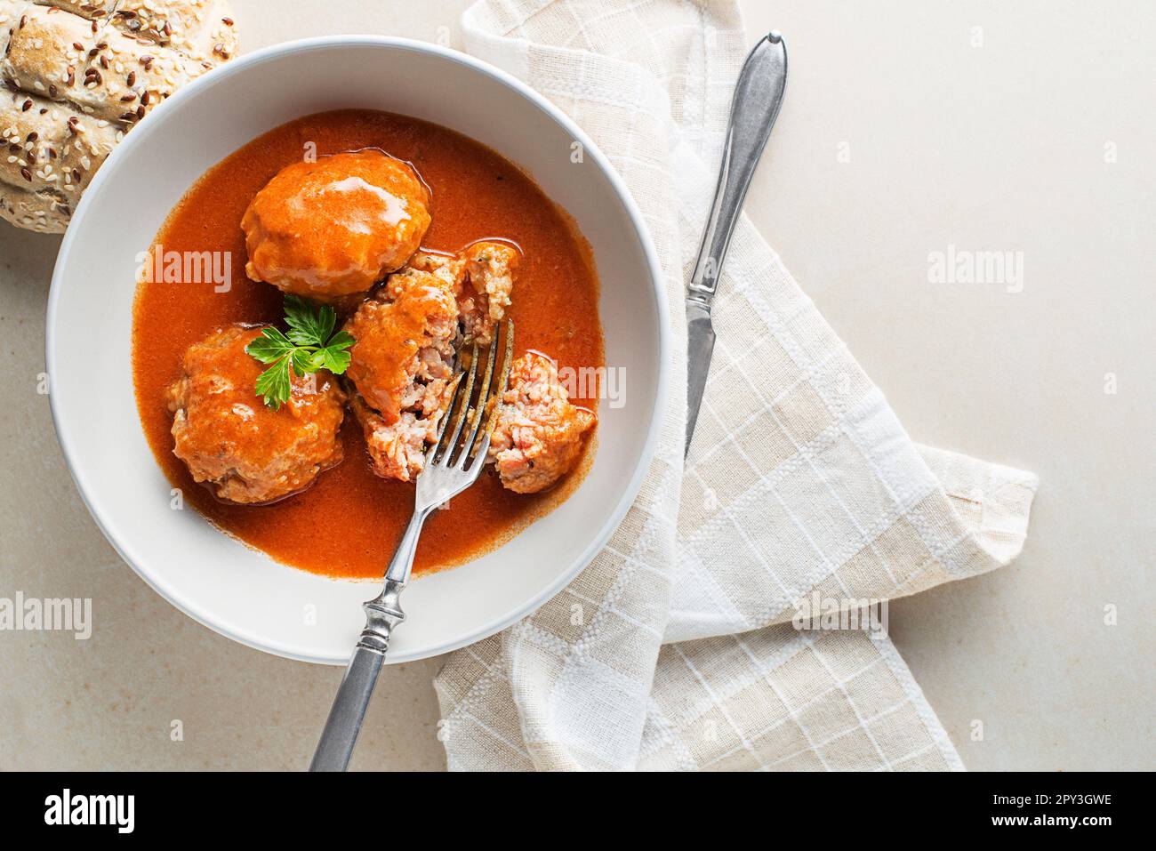 Gebratene Fleischbällchen, geschmort in Tomatensauce, serviert auf einem weißen Tisch. Ich esse mit Rind gebratene Fleischbällchen in Tomatensoße. Stockfoto