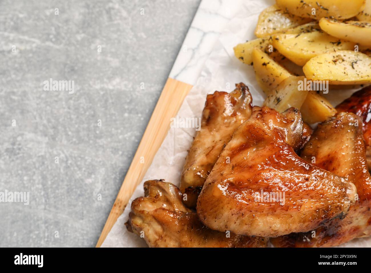 Köstliche gebratene Hähnchenflügel serviert mit gebackenen Kartoffeln ...