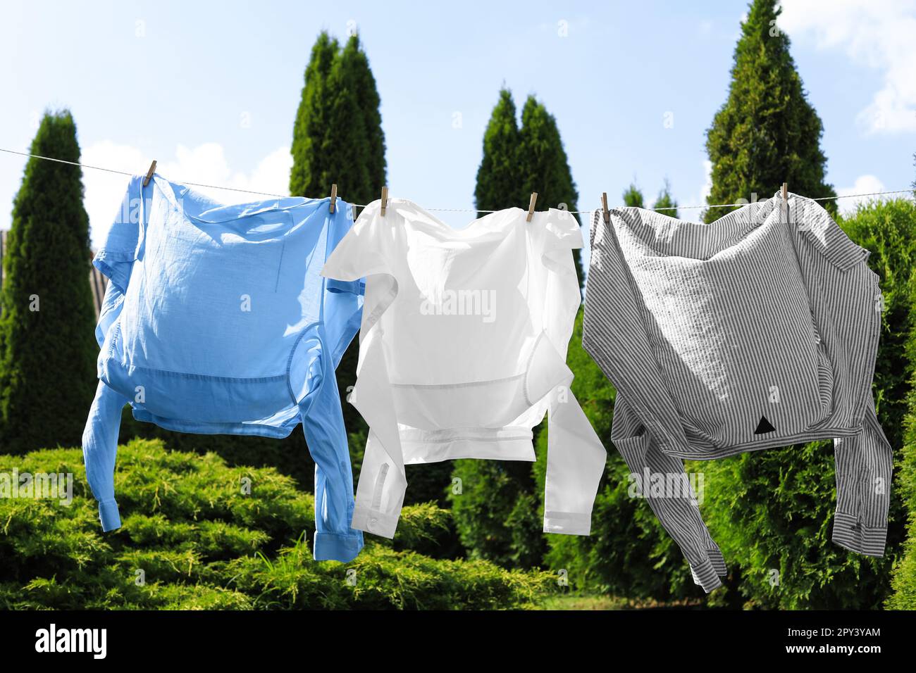 Saubere Wäsche hängt im Garten an der Wäscheleine. Wäschetrockner Stockfoto