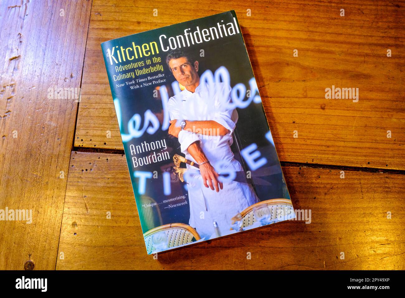 NEW ORLEANS, LA, USA - 28. APRIL 2023: Titelseite des Buchs „Kitchen Confidential: Adventures in the Culinary Underbelly“ auf einem hölzernen Tisch Stockfoto