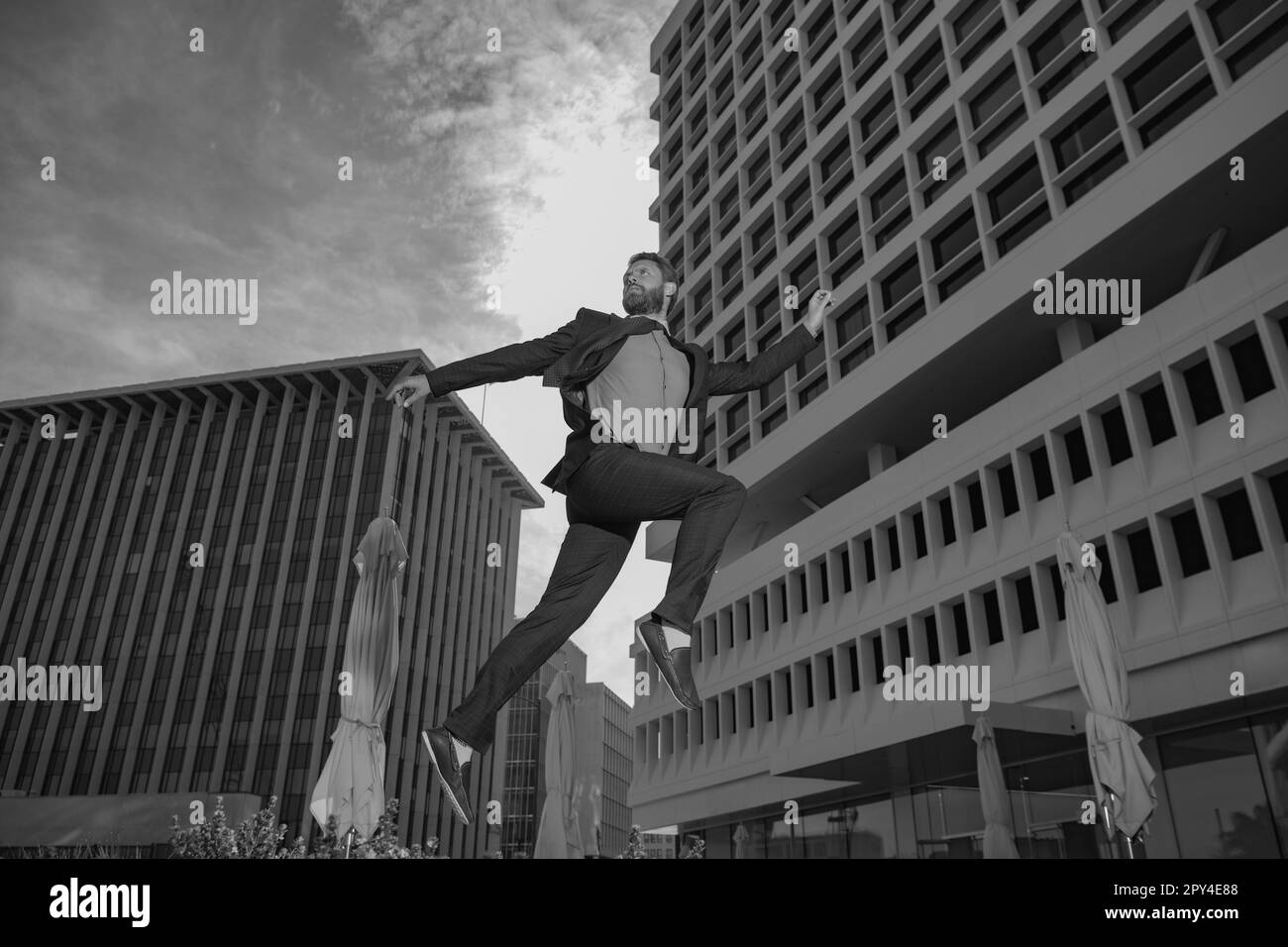 Geschäftsmann läuft, springt. Konzept des schnellen Geschäfts mit dem laufenden Geschäftsmann. An der Spitze zu bleiben. Stockfoto