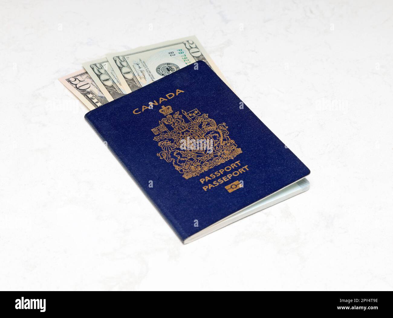 Kanadischer Pass und amerikanische Dollar auf weißem Marmorhintergrund Stockfoto