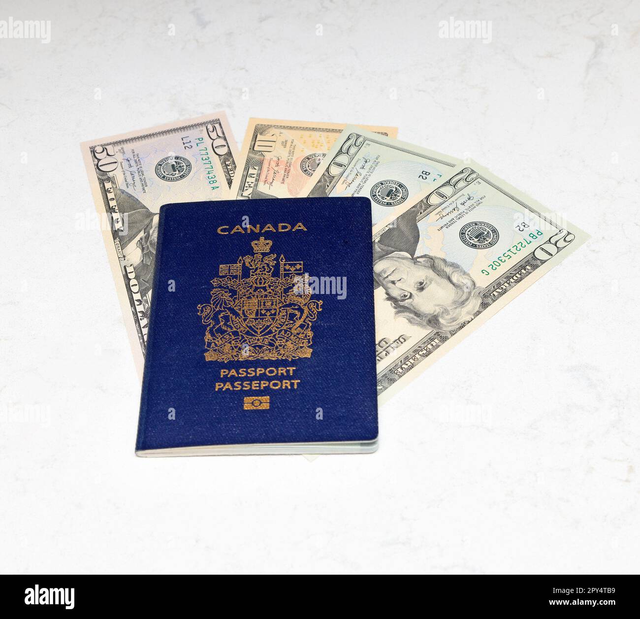Kanadischer Pass und amerikanische Dollar auf weißem Marmorhintergrund Stockfoto