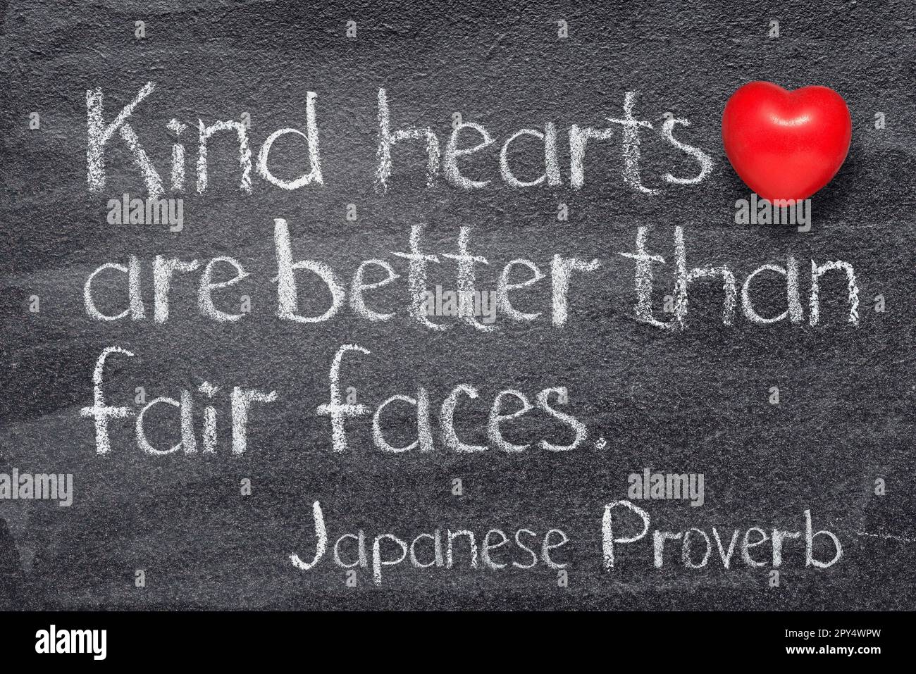 Freundliche Herzen sind besser als schöne Gesichter. Japanisches Sprichwort, geschrieben auf einer Tafel mit rotem Herzsymbol Stockfoto