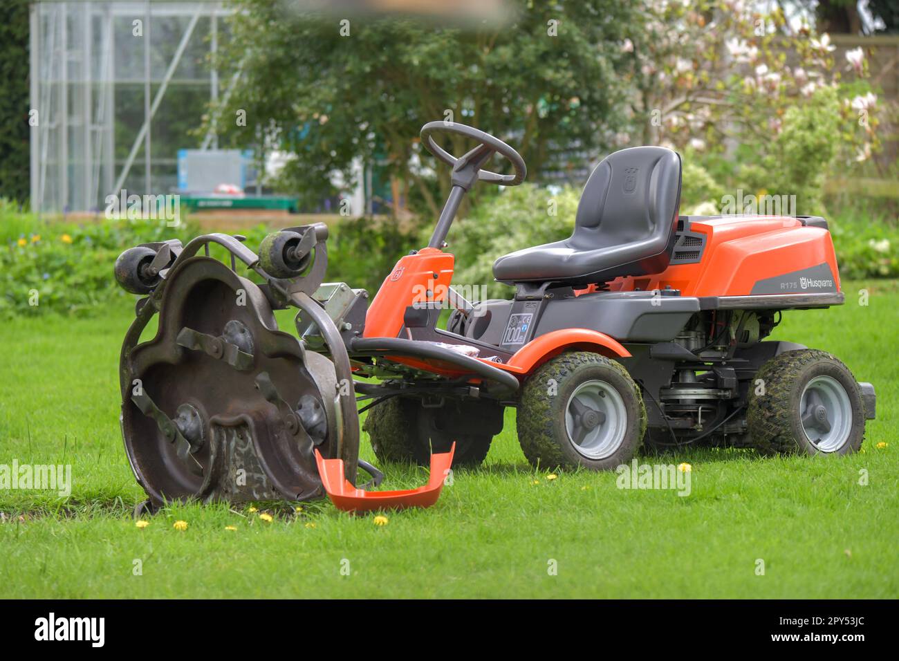 Ein Aufsitzmäher, Mulchmäher, mit angehobenem Bett der Schneidmesser, damit er gewartet werden kann, an einem Frühlingstag Stockfoto