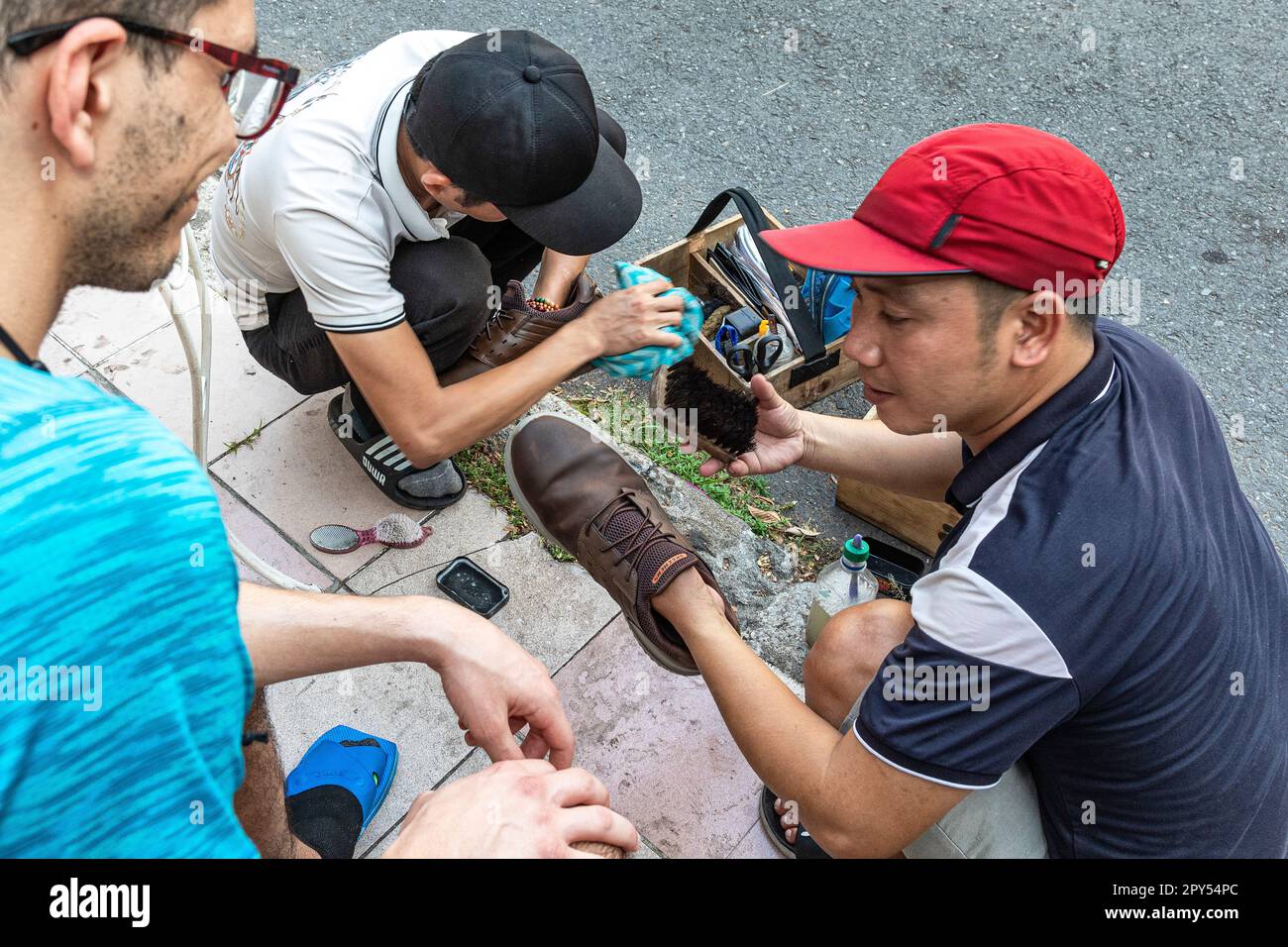 Vietnamesische Schuhputzer, die an amerikanischen Touristen in Ho-Chi-Minh-Stadt, Vietnam arbeiten Stockfoto