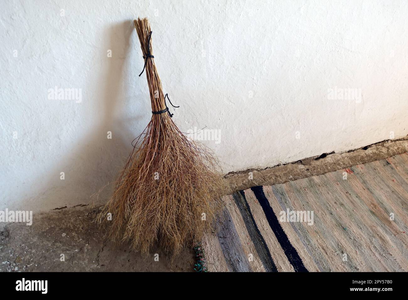 Handgewebter klassischer Teppich und handgemachter Grasbesen, klassische Dorfartikel Stockfoto
