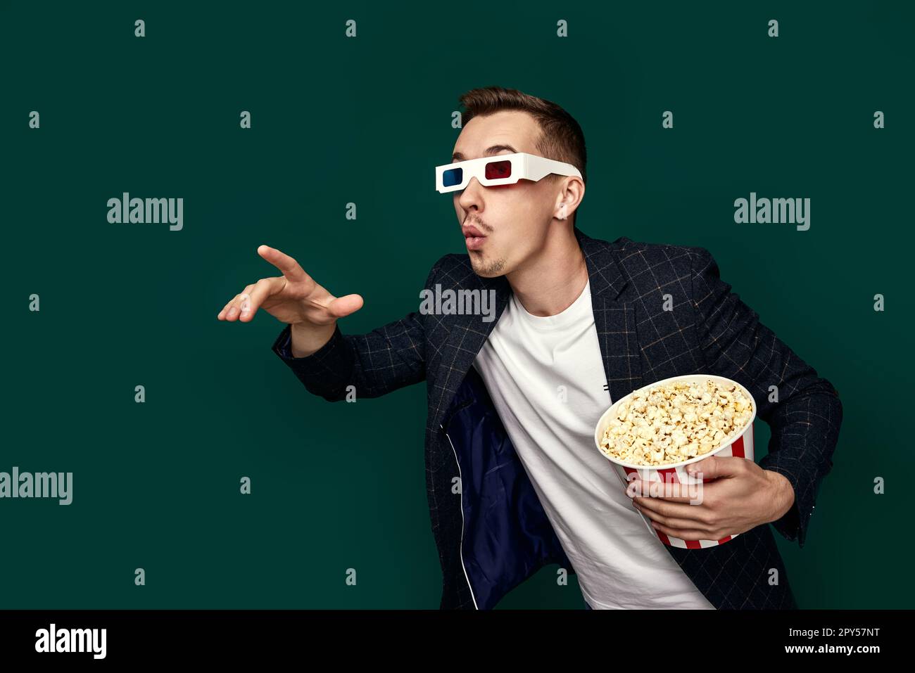 Ein Mann in 3D-Brille mit einem großen Eimer Popcorn Stockfoto