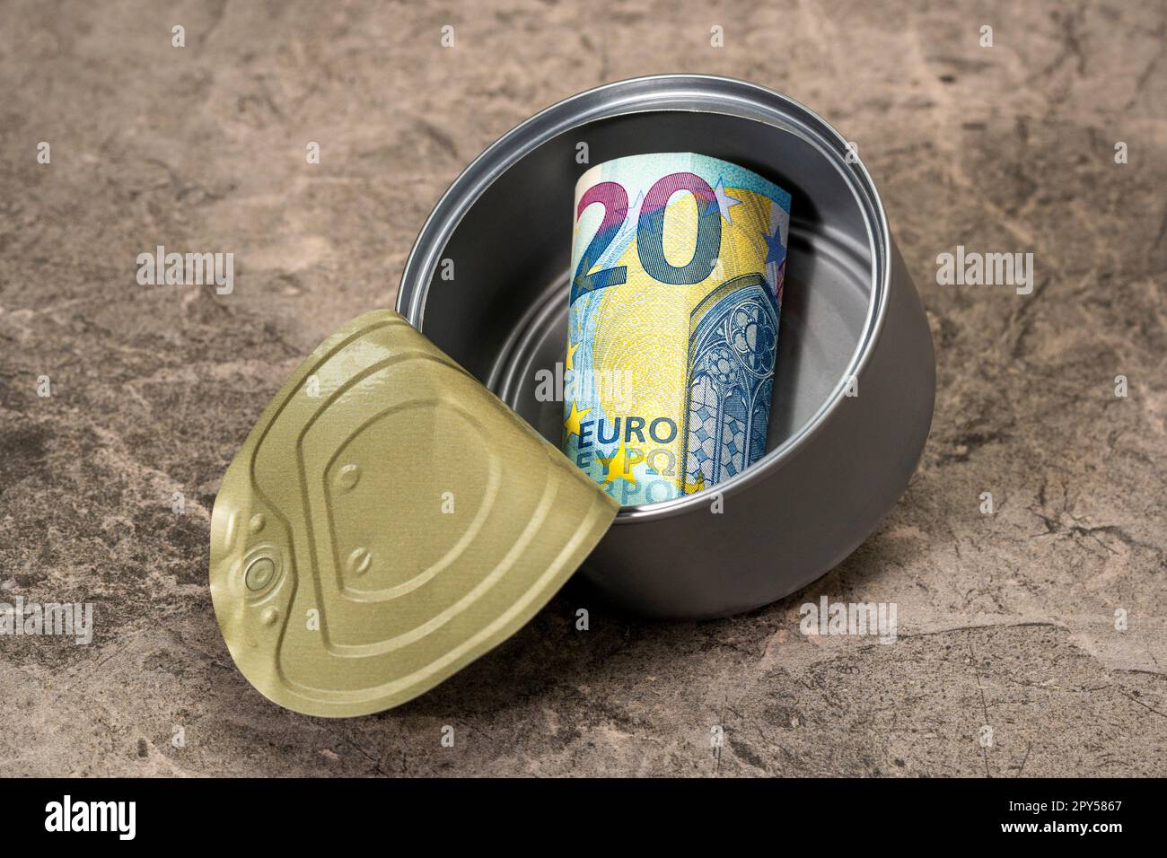 Zwanzig Euro in einer Blechdose, die auf den Steinhintergrund fällt Stockfoto