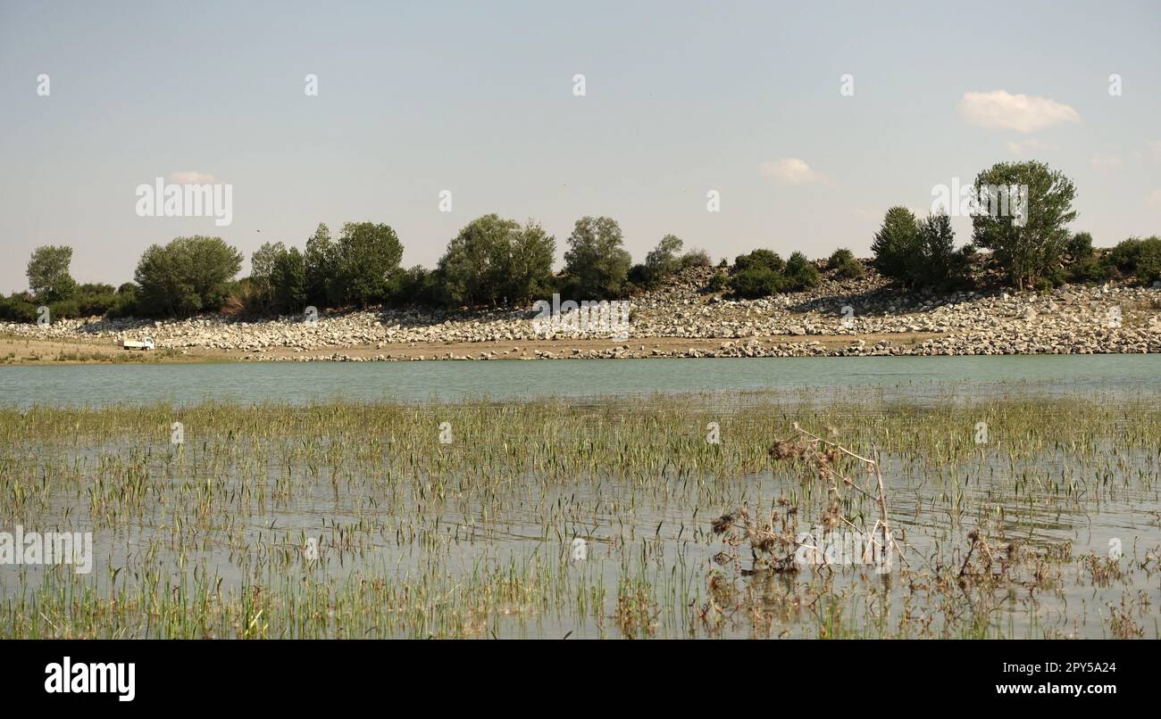Der Bewässerungsdamm eines Dorfes hat durch die Dürre, den Teich, dessen Wasser zurückgegangen ist, die tragische Situation der Dürre und den Bewässerungsteich viel Wasser verloren Stockfoto