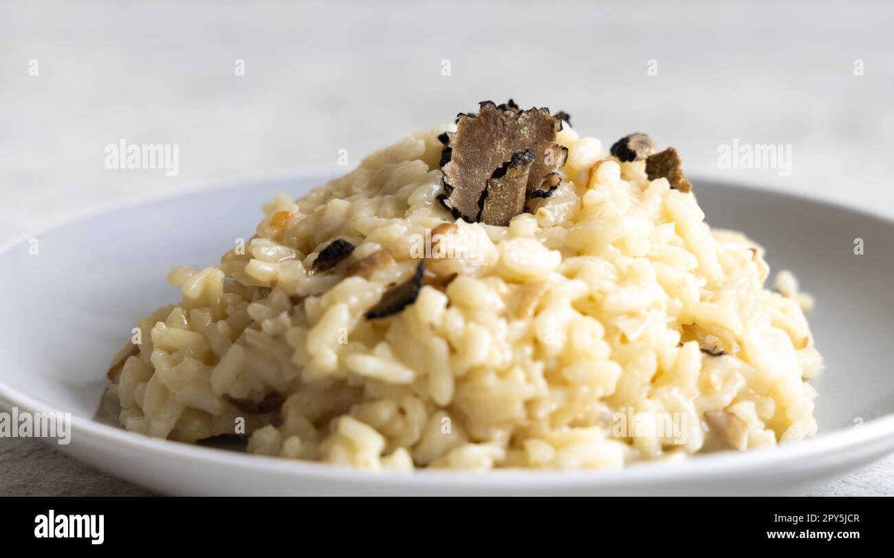 Risotto mit Porcini-Pilzen und schwarzen Trüffeln, serviert auf einem Teller mit Blick von oben, Gourmet-Cousine Stockfoto