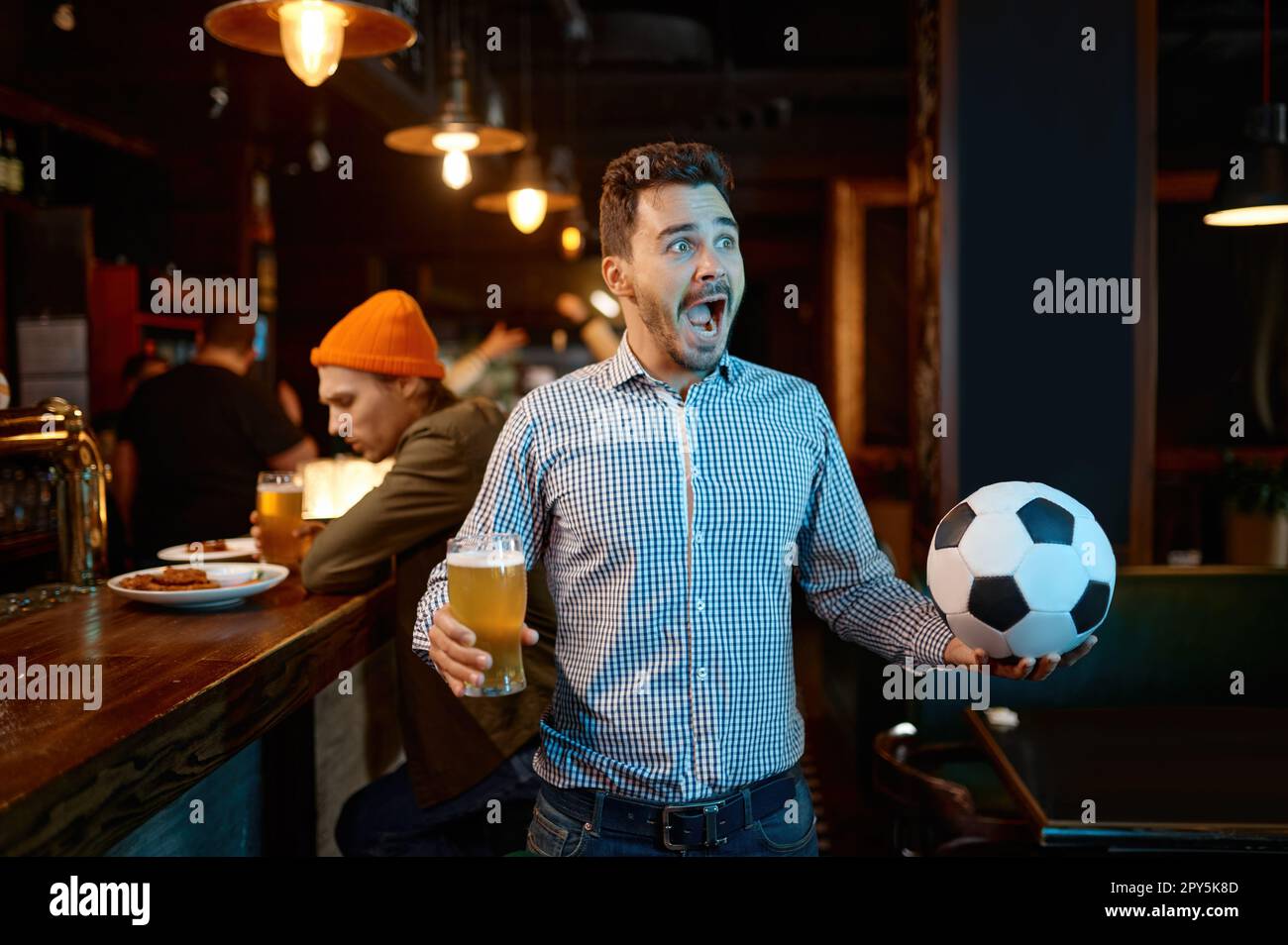 Junger Mann Fußball macht Spaß beim Anschauen von Sportspielen in der Bar und jubeln Stockfoto