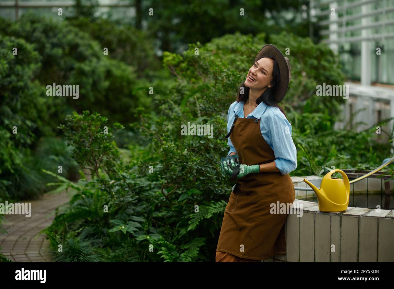 Positiv lächelnde Gärtnerin mit Blumentöpfen im handselektiven Fokus Stockfoto