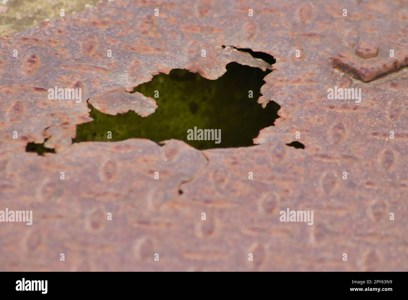 Rostige Metallplatte mit Korrosionslöchern auf alter korrodierter diamantplatte zeigt bei Dampf-Punk-Szenarien mit beschädigter Oberfläche bei Stahlplatten der Kategorie Industrie Grunge-Stahl und verwitterten Metallrost Stockfoto